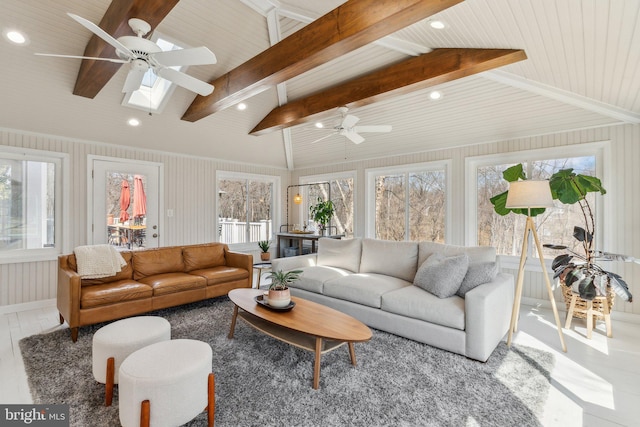 living room featuring a ceiling fan, lofted ceiling with skylight, and recessed lighting