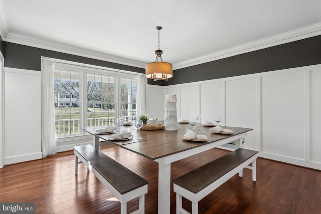 dining room featuring a decorative wall, crown molding, a wainscoted wall, and wood finished floors