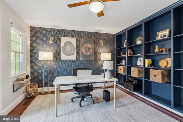 home office with visible vents, baseboards, wood finished floors, and wallpapered walls