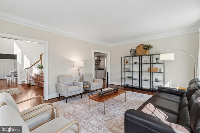 living area with stairway, baseboards, wood finished floors, and ornamental molding