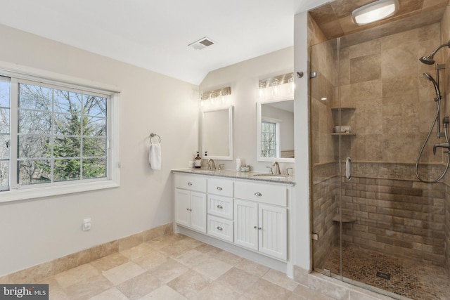 full bath featuring visible vents, a stall shower, baseboards, and a sink