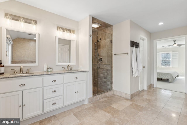 ensuite bathroom with connected bathroom, a stall shower, baseboards, and a sink