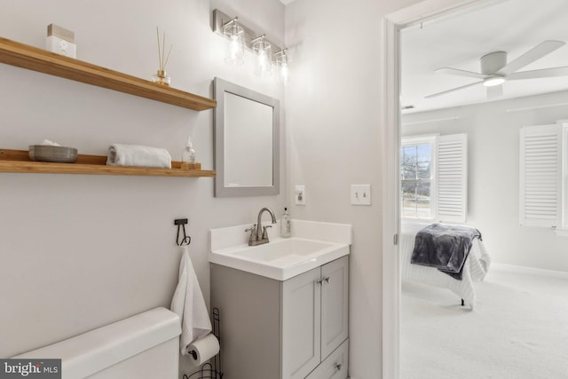 ensuite bathroom with toilet, a ceiling fan, connected bathroom, baseboards, and vanity