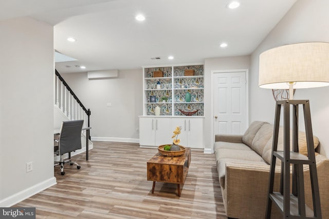 sitting room with stairway, recessed lighting, light wood-style floors, and baseboards