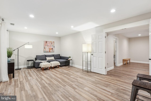 living area featuring recessed lighting, baseboards, and light wood finished floors