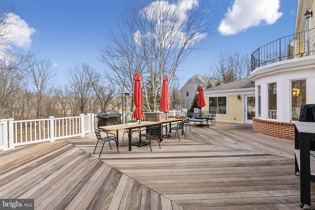 deck with grilling area and outdoor dining space