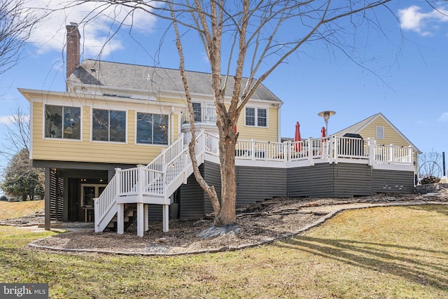 back of house featuring a yard, a wooden deck, a chimney, and stairway