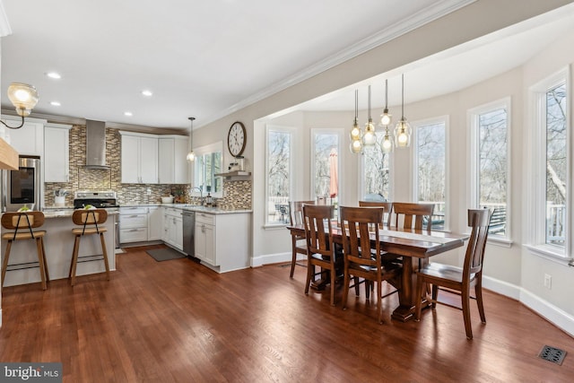 dining space with visible vents, dark wood-style floors, recessed lighting, crown molding, and baseboards