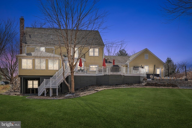 rear view of house with stairway, a lawn, and a wooden deck