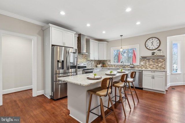 kitchen featuring appliances with stainless steel finishes, wall chimney exhaust hood, dark wood-style flooring, and ornamental molding