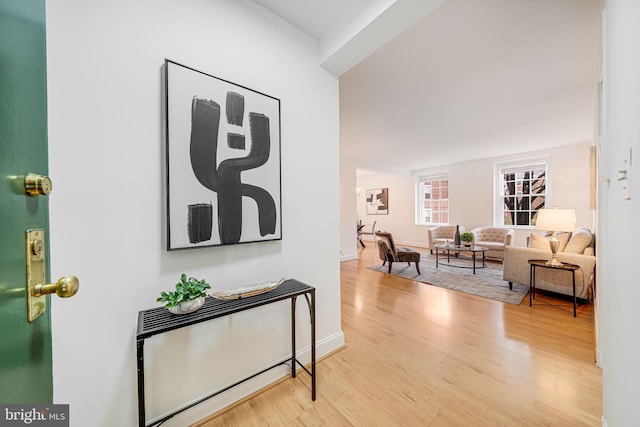 corridor with baseboards and wood finished floors