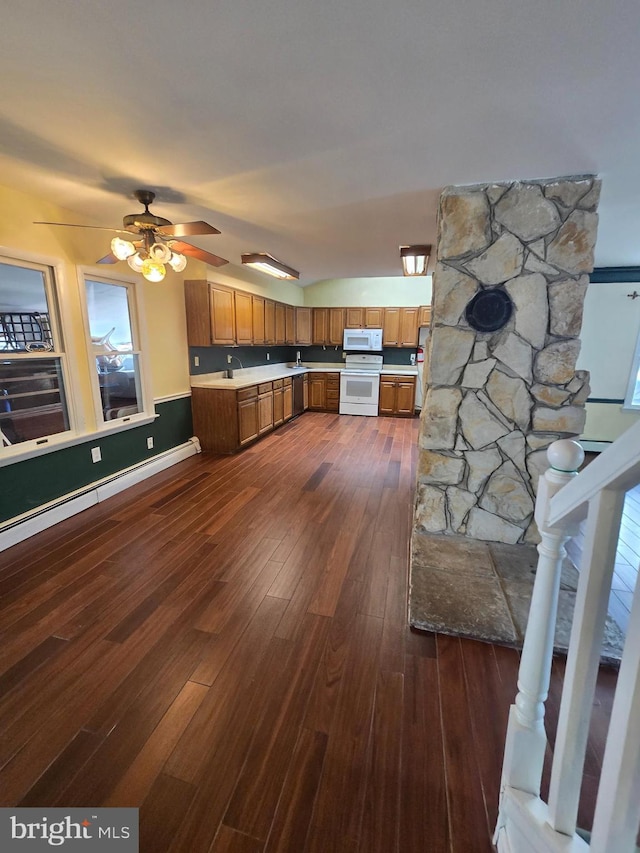 kitchen featuring white appliances, brown cabinetry, a ceiling fan, dark wood finished floors, and light countertops