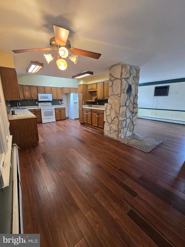 kitchen featuring white appliances, dark wood-style flooring, ceiling fan, a baseboard heating unit, and brown cabinets