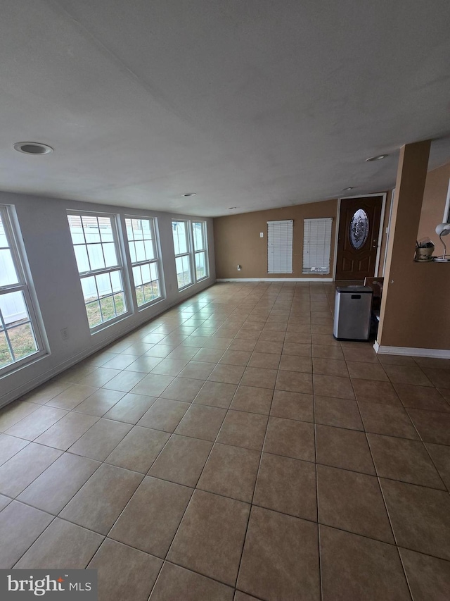 unfurnished living room with tile patterned floors and baseboards