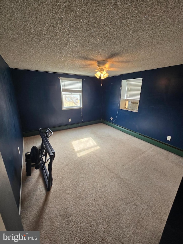 spare room featuring baseboards, a textured ceiling, and carpet