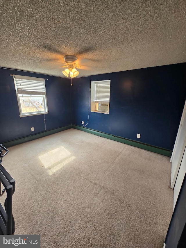 carpeted empty room featuring a ceiling fan, baseboards, and a textured ceiling