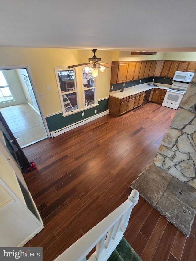 kitchen with ceiling fan, dark wood finished floors, light countertops, brown cabinets, and white appliances