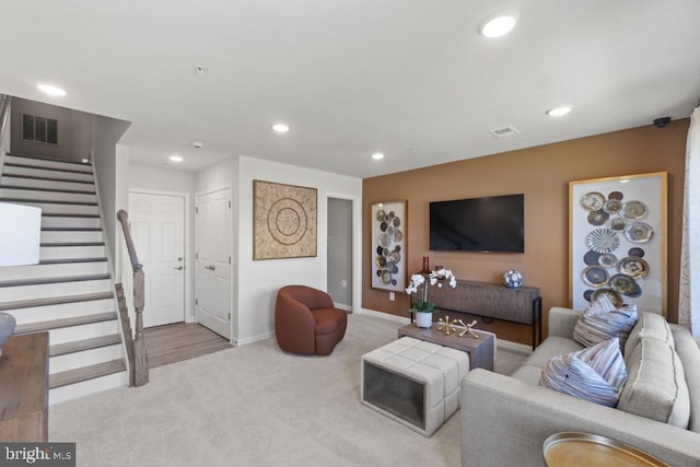 carpeted living room with stairs, recessed lighting, visible vents, and baseboards