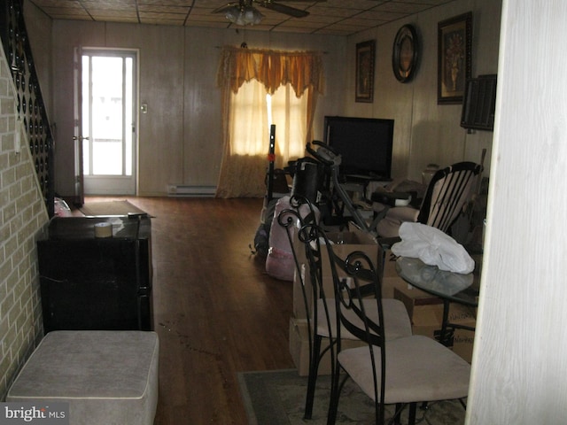 interior space featuring a drop ceiling, wood finished floors, and a ceiling fan