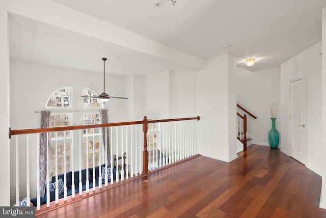 spare room with a ceiling fan, stairs, baseboards, and hardwood / wood-style flooring