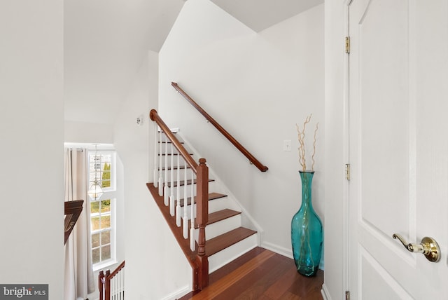 stairway with baseboards and wood finished floors