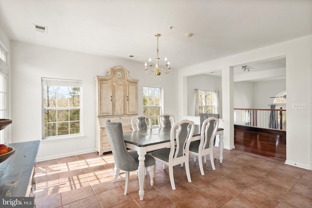 dining room featuring a notable chandelier, baseboards, and visible vents