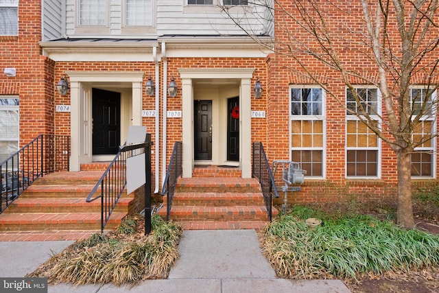 entrance to property featuring brick siding