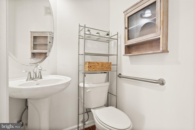 bathroom with toilet and baseboards