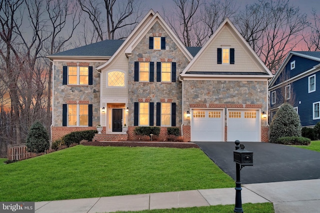 view of front of house with stone siding, a lawn, concrete driveway, and a garage