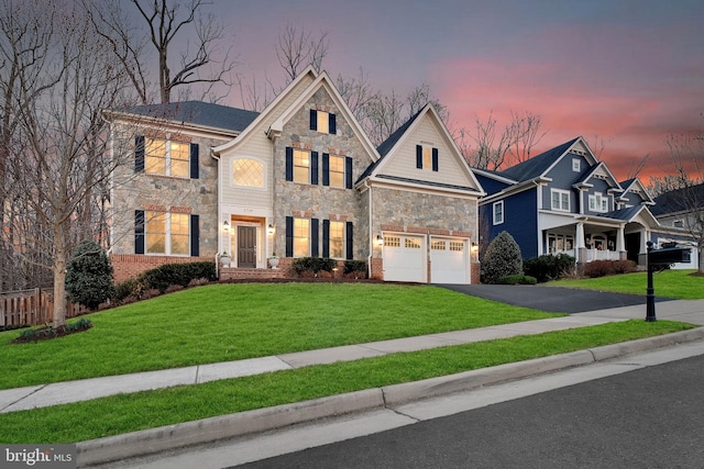 traditional-style home with fence, driveway, an attached garage, stone siding, and a lawn