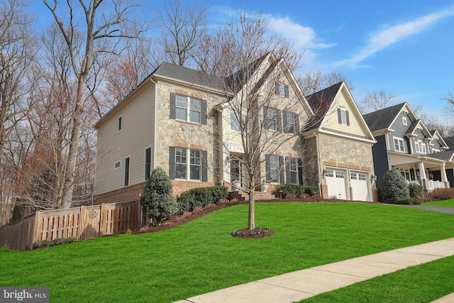 traditional home featuring stone siding, a front lawn, a garage, and fence