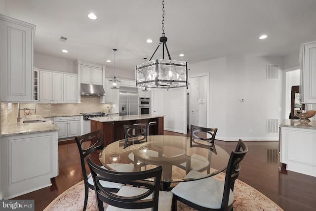 dining space with visible vents, recessed lighting, an inviting chandelier, and dark wood-style flooring