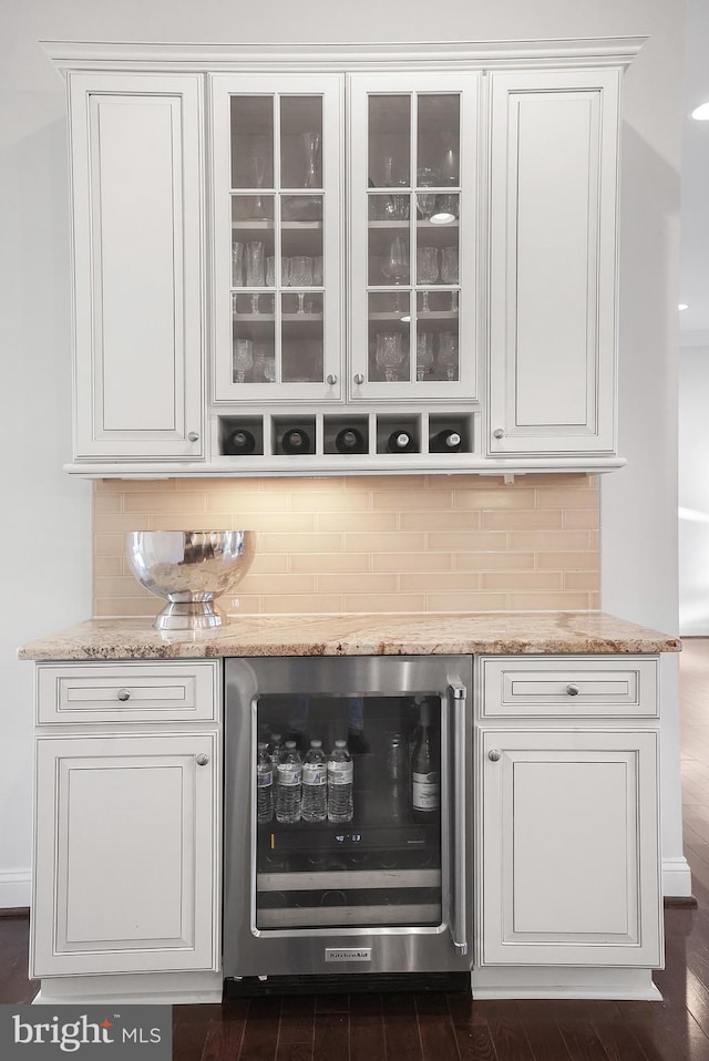 bar with decorative backsplash, wine cooler, a dry bar, and dark wood finished floors