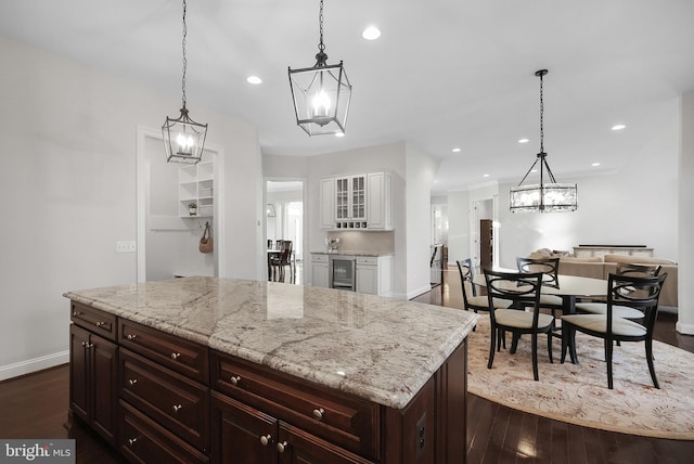 kitchen with wine cooler, an inviting chandelier, dark wood-style floors, and white cabinets