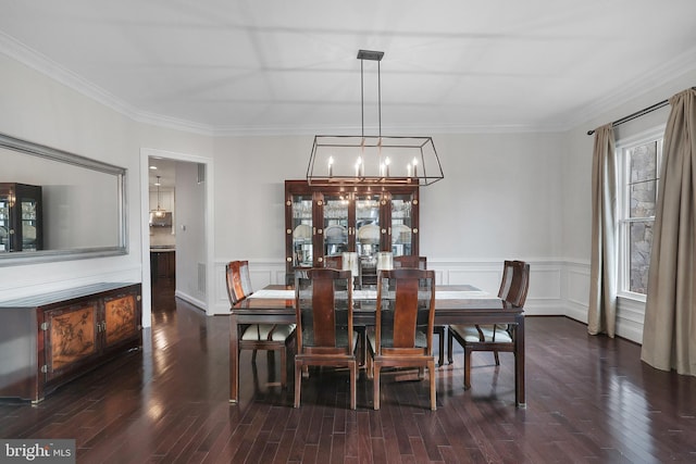 dining space with a chandelier, a decorative wall, ornamental molding, and wood finished floors