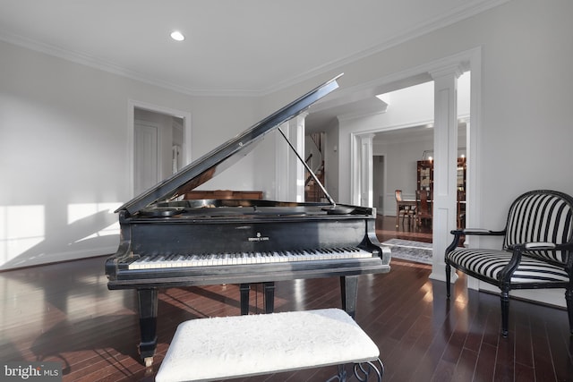 living area featuring wood finished floors, recessed lighting, crown molding, decorative columns, and baseboards