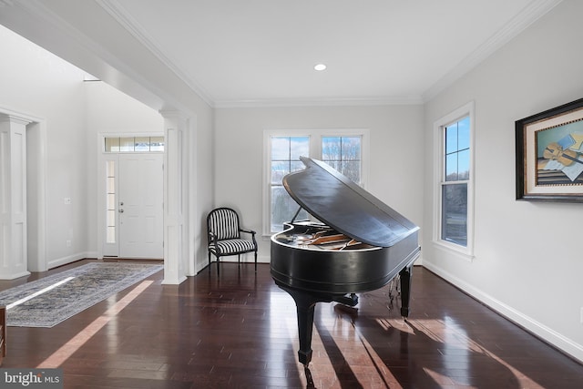 living area with baseboards, hardwood / wood-style flooring, and ornate columns