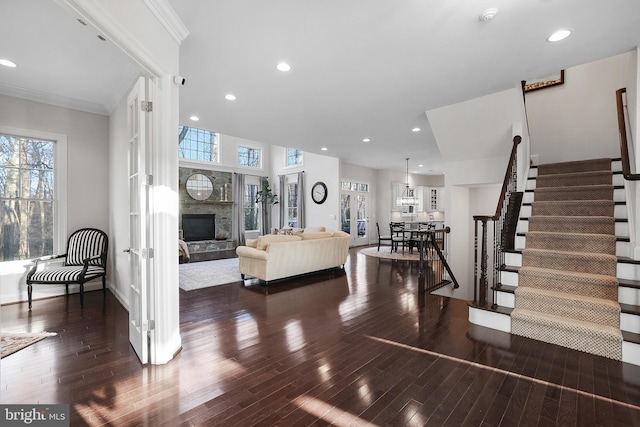 interior space with stairs, ornamental molding, a fireplace, and a healthy amount of sunlight