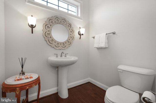 bathroom with toilet, wood finished floors, and baseboards