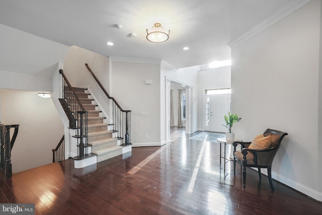 foyer with crown molding, baseboards, and wood-type flooring