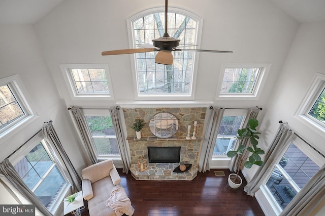 living area with visible vents, high vaulted ceiling, a ceiling fan, wood finished floors, and a fireplace