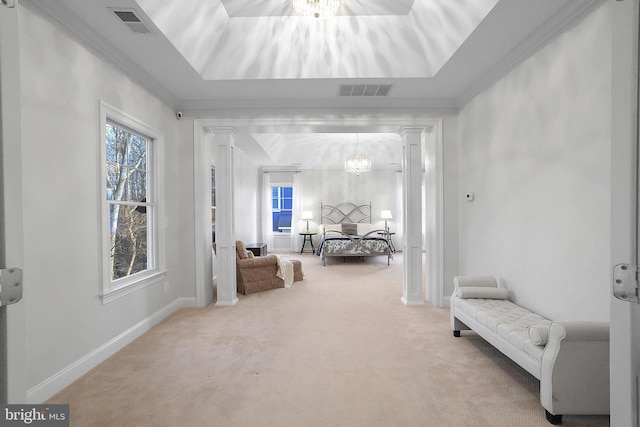 sitting room with a tray ceiling, carpet, and visible vents