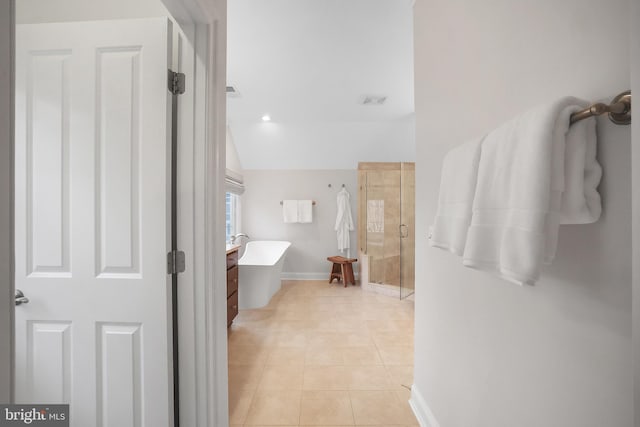 full bath featuring tile patterned flooring, a shower stall, baseboards, and a freestanding bath