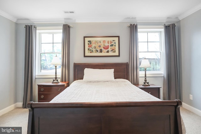 carpeted bedroom with visible vents, baseboards, and ornamental molding