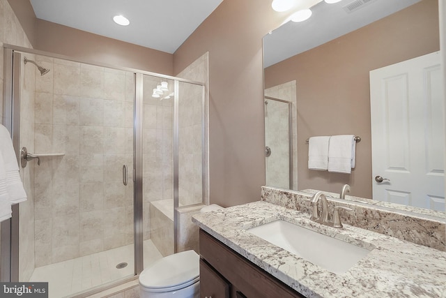 bathroom with vanity, toilet, visible vents, and a stall shower