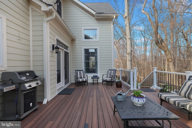 wooden terrace with a grill and an outdoor hangout area