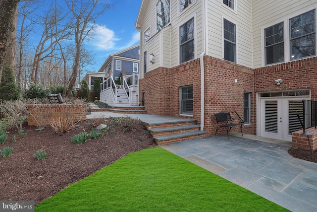 view of home's exterior with a patio, french doors, and brick siding