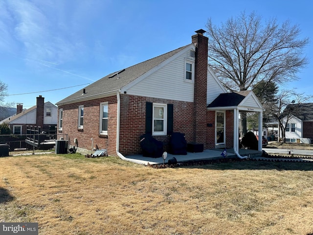 exterior space featuring brick siding, fence, central AC, a lawn, and a patio