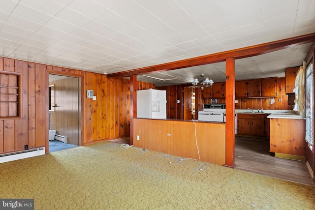 kitchen with a chandelier, wooden walls, white appliances, and a baseboard heating unit