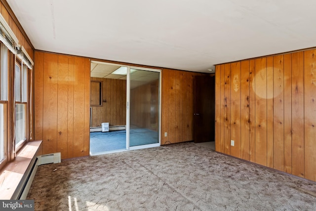 interior space featuring carpet floors, wooden walls, and baseboard heating